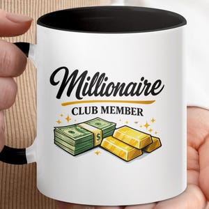 May include: White ceramic mug with a black interior and handle. The mug features the text "Millionaire CLUB MEMBER" in a stylish font, along with illustrations of a stack of cash and gold bars. The design includes gold star accents.