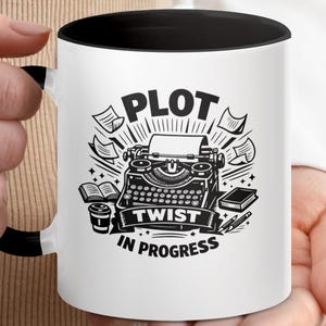 May include: White ceramic mug with a black interior and handle. The mug features a black and white illustration of a vintage typewriter, paper, and the text "PLOT TWIST IN PROGRESS". A perfect gift for writers.