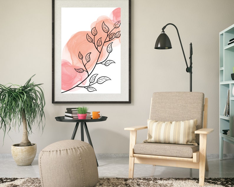 May include: A framed print with a black and white illustration of a branch with leaves on a pink watercolor background.