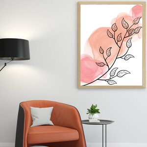 May include: A framed print with a black and white illustration of a branch with leaves against a background of pink watercolor washes.