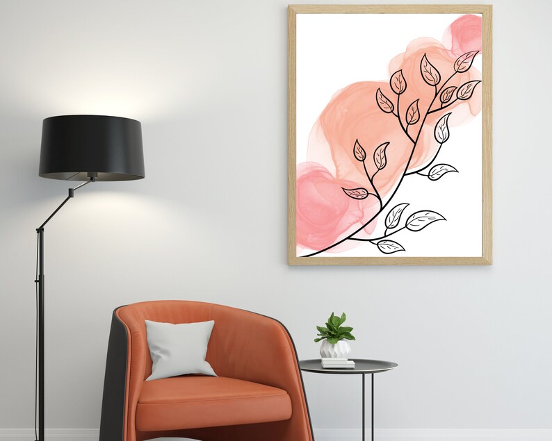 May include: A framed print with a black and white illustration of a branch with leaves against a background of pink watercolor washes.
