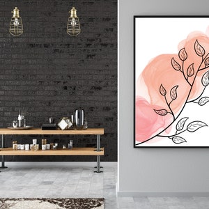 May include: A black framed print with a watercolor-style background in shades of pink and orange. A black line drawing of a branch with leaves is superimposed on the background.