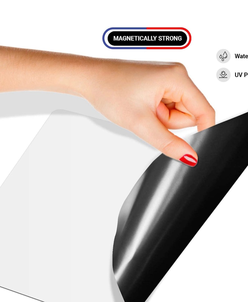 May include: A white magnetic sheet with a black magnetic backing. The sheet is being peeled back to reveal the black backing. The text "Magnetically Strong" is visible in red and blue.