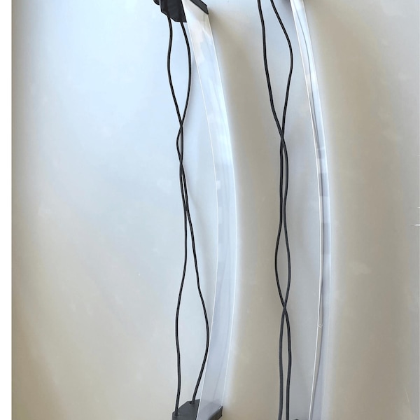 May include: Two clear plastic panels with black elastic straps attached to black plastic bases. The panels are curved and flexible.