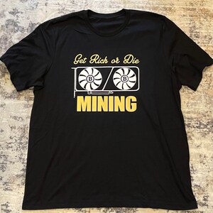 May include: Black t-shirt with a white graphic of two computer fans with the text "Get Rich or Die Mining" in yellow.