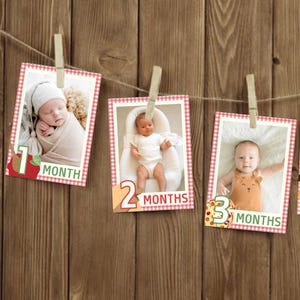 May include: A series of five baby photos, each clipped to a string with a wooden clothespin. Each photo is framed with a red and white checkered border and labeled with the baby's age in months, from one to five.