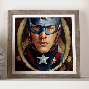 Può includere: Un'illustrazione incorniciata di Capitan America, un supereroe che indossa un costume blu, rosso e bianco con una stella sul petto. Il suo viso è visibile e sta guardando direttamente lo spettatore.