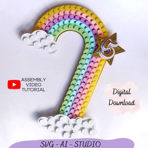 Puede incluir: Un arcoíris hecho de coloridos bloques de Lego con una nube blanca a cada lado. Una estrella dorada con el número 5 en su interior está en el lado derecho del arcoíris. El texto "Assembly Video Tutorial" está en el lado izquierdo de la imagen. El texto "Digital Download" está en el lado derecho de la imagen. El texto "SVG - AI - STUDIO" está en la parte inferior de la imagen.