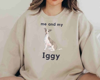 Könnte beinhalten: Ein hellbeiger Pullover mit einem Grafikdruck eines kleinen Hundes und dem Text "me and my Iggy" auf der Vorderseite.