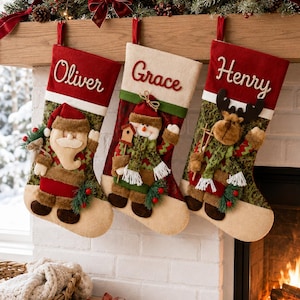 Può includere: Tre calze natalizie personalizzate appese in fila. La calza a sinistra è rossa con un'applicazione di Babbo Natale e il nome Oliver. La calza centrale è color crema con un'applicazione di pupazzo di neve e il nome Grace. La calza a destra è rossa con un'applicazione di renna e il nome Henry.