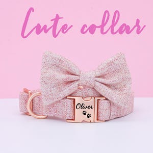May include: A pink dog collar with a matching pink bow tie and a gold metal buckle. The buckle has the name "Oliver" engraved on it with paw prints.