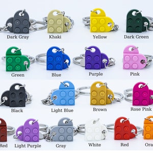 May include: A set of 16 heart-shaped keychains made from LEGO bricks in various colors, including dark gray, khaki, yellow, dark green, green, blue, purple, pink, black, light blue, brown, rose pink, dark red, light purple, gray, white, red, and orange.
