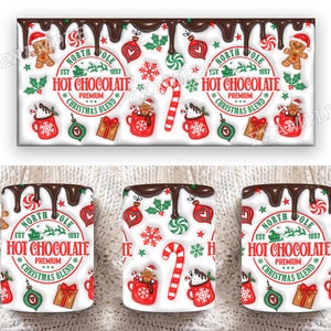 K&ouml;nnte beinhalten: Wei&szlig;e Keramiktasse mit einem roten, gr&uuml;nen und wei&szlig;en Weihnachtsdesign. Die Tasse hat ein Schokoladen-Tropf-Design und den Text "North Pole Est 1897 Hot Chocolate Premium Christmas Blend".