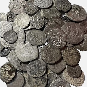 May include: A collection of silver coins with Arabic script. The coins are worn and have a patina.