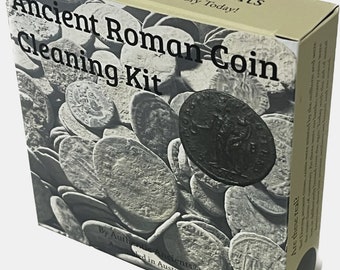 Op de afbeelding: Een doos voor een reinigingsset voor oude Romeinse munten. De doos is bruin met een afbeelding van een stapel oude Romeinse munten. De tekst op de doos luidt "Authentic Ancients Own Your Piece of History Today! Ancient Roman Coin Cleaning Kit By Authentic Ancients Assembled in Australia Are these real?"