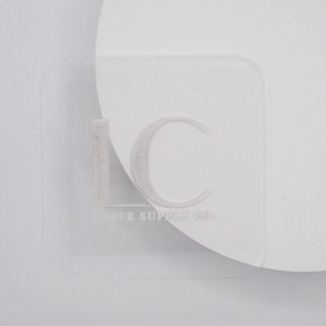 Puede incluir: Una placa cuadrada de acrílico blanco con el texto "LC Laser Supply Co." grabado en la superficie.