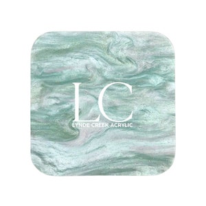 May include: Square coaster with a green and white marbled design and silver glitter. The coaster has the letters "LC" and the text "Lynde Creek Acrylic" in white.