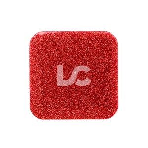 Peut inclure: Un compact rouge carré pailleté avec des coins arrondis.