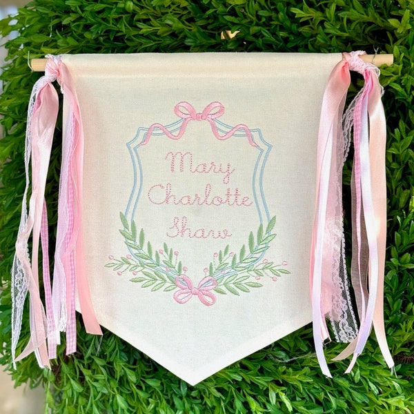 Diseño de bordado a máquina con doble cresta floral y monograma de lazos y ramas para bebé
