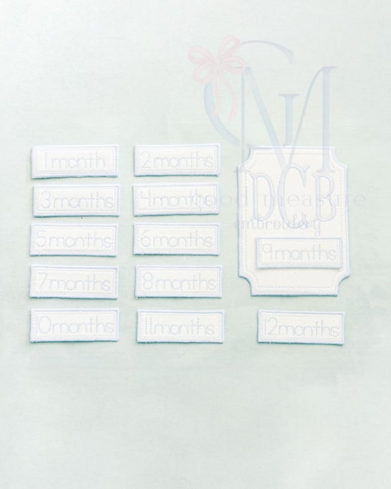 May include: White embroidered fabric pieces with text indicating months, from 1 to 12 months. The design includes a larger, decorative piece with the text "measure embroidery". The background is a light blue color.