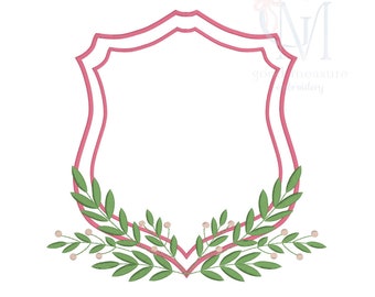 May include: A pink double-lined shield shape with a green leafy wreath around the bottom. The wreath has small white berries.