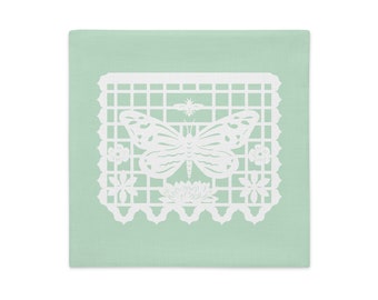 Butterfly decorative pillow sham 18"x18" in green with white papel picado from the book A Is For Alpaca And Amigos © by Lisa Osterman
