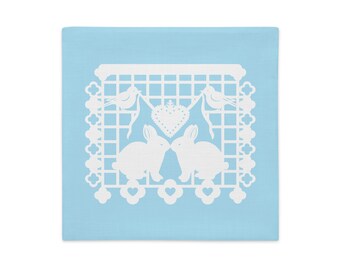 Bunny Rabbit decorative pillow sham 18"x18" in baby blue with white papel picado from the book A Is For Alpaca And Amigos © by Lisa Osterman