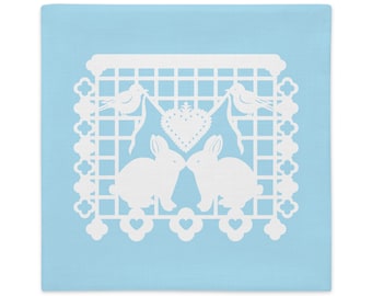 Bunny Rabbit decorative pillow sham 22"x22" in baby blue with white papel picado from the book A Is For Alpaca And Amigos © by Lisa Osterman