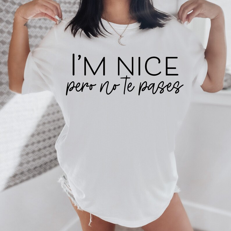 May include: White t-shirt with the text "I'm nice pero no te pases" printed in black.