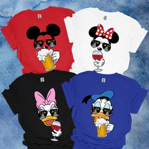 May include: Four t-shirts featuring Disney characters Mickey Mouse, Minnie Mouse, Donald Duck, and Daisy Duck. Each character is wearing sunglasses with a fireworks reflection and holding a drink. Mickey and Donald are holding a beer, while Minnie and Daisy are holding a glass of wine.