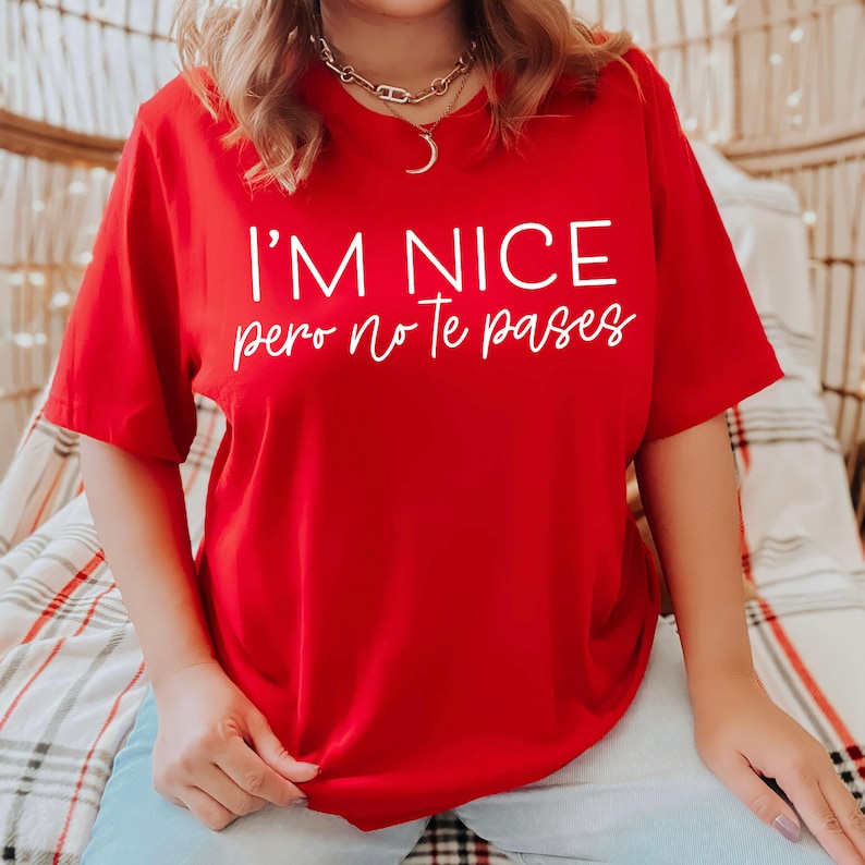 May include: Red t-shirt with white text that reads "I'm nice pero no te pases".