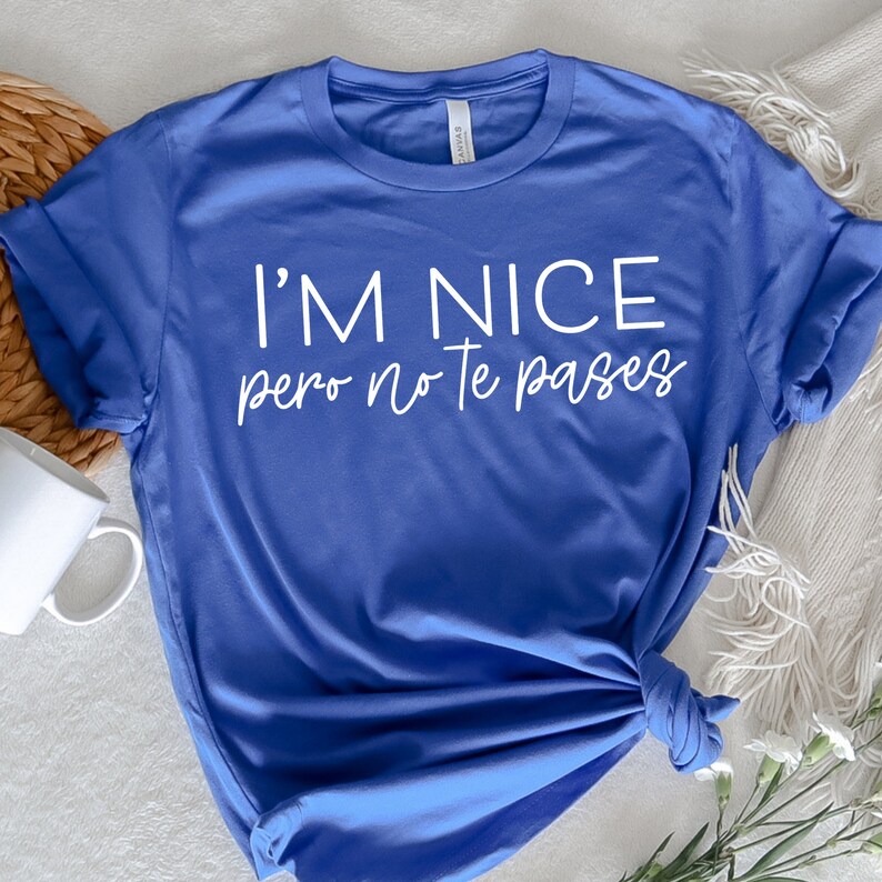 May include: A royal blue t-shirt with the text "I'm nice pero no te pases" in white.