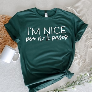 May include: A dark green t-shirt with the text "I'm nice pero no te pases" in white.