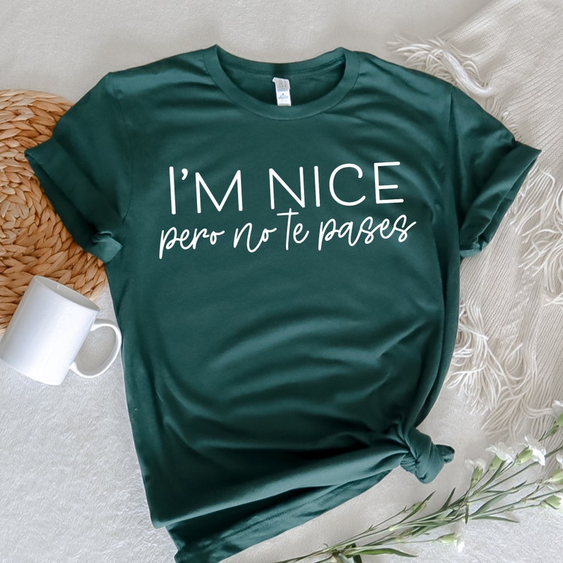 May include: A dark green t-shirt with the text "I'm nice pero no te pases" in white.