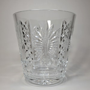Peut inclure: Un verre en cristal clair, taillé, de forme cylindrique et large. Le verre présente des motifs géométriques et floraux complexes, créant un effet scintillant. La base est de conception circulaire et solide. Cette verrerie élégante convient à diverses boissons.