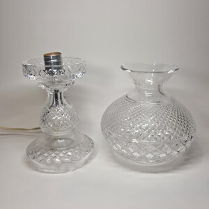 May include: Two clear glass objects with diamond-cut patterns. One is a lamp base with a silver socket and a power cord. The other is a round vase. Both are on a white background.