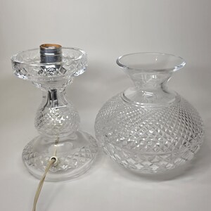 May include: Clear glass lamp base and shade. The lamp base has a diamond pattern and a bulb socket. The shade is a clear glass globe with a diamond pattern. The lamp is unplugged.
