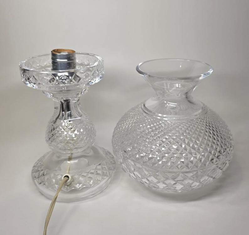 May include: Clear glass lamp base and shade. The lamp base has a diamond pattern and a bulb socket. The shade is a clear glass globe with a diamond pattern. The lamp is unplugged.
