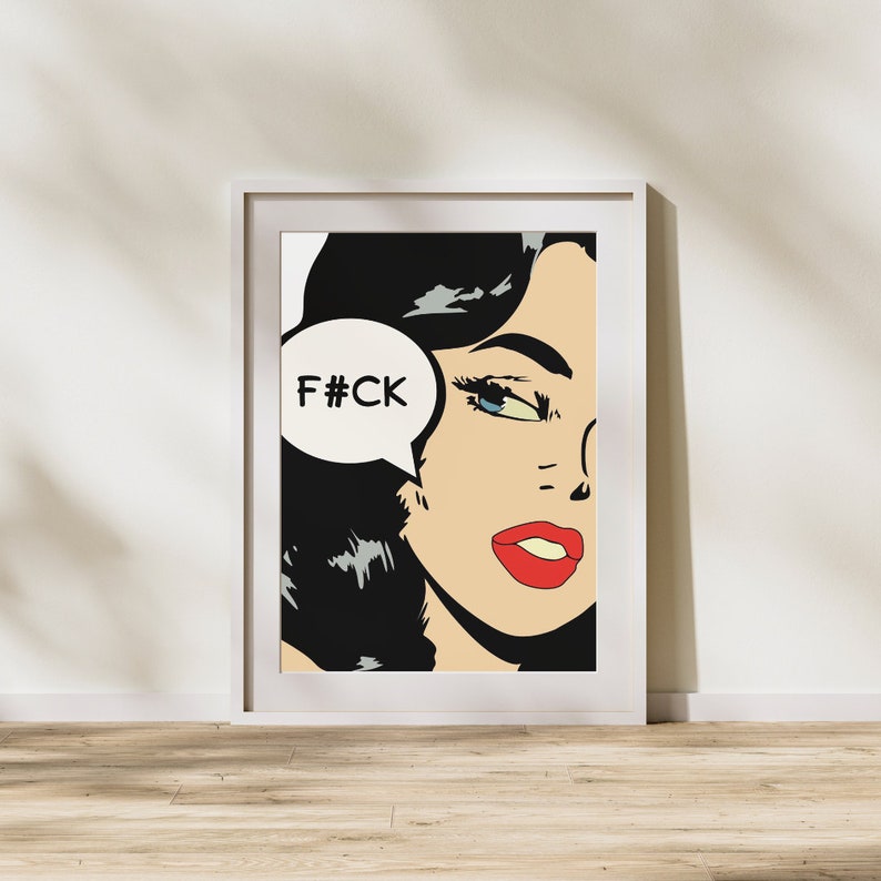 May include: A framed pop art print of a woman with black hair and red lips. The woman is looking to the right and has a speech bubble above her head that says "F#CK".
