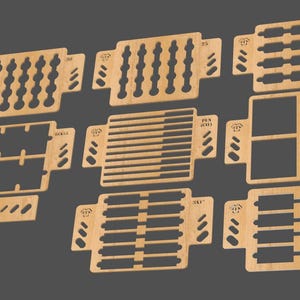 Puede incluir: Conjunto de ocho plantillas de madera para manualidades. Las plantillas están hechas de madera marrón claro y tienen varias formas y tamaños. Las plantillas están etiquetadas con números y letras.