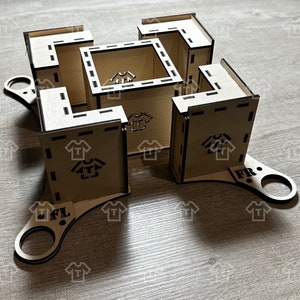 Pode incluir: Uma caixa de madeira com formato quadrado e um design único. A caixa tem uma série de compartimentos abertos e é feita de madeira marrom clara. A caixa tem duas alças nas laterais etiquetadas como "FL" e "FR".