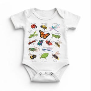 May include: White baby bodysuit with colourful illustrations of insects such as a ladybug, butterfly, and dragonfly. Each insect is labelled with its name in a playful font. The bodysuit has short sleeves and snap closures.