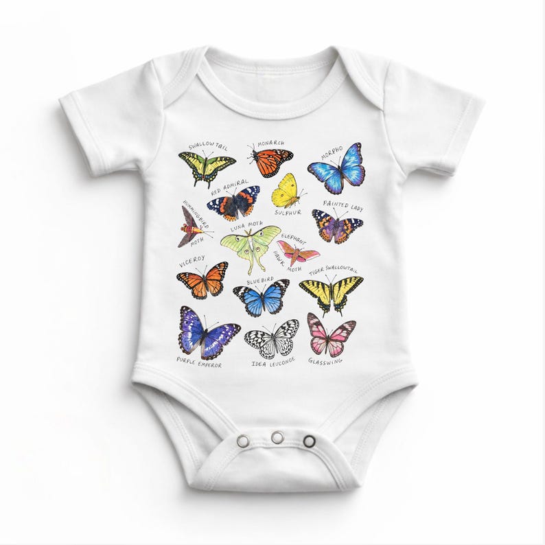 May include: White baby bodysuit featuring colorful illustrations of various butterfly species, each labeled with its name. The butterflies are in shades of orange, blue, yellow, and purple. The bodysuit has short sleeves and snap closures.