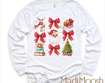 Puede incluir: Camiseta blanca de manga larga con un diseño navideño. El diseño incluye un reno, lazos rojos, Papá Noel, regalos envueltos, un árbol de Navidad y un trineo. El texto "MadiMoosh premium clothing" está en la parte inferior.