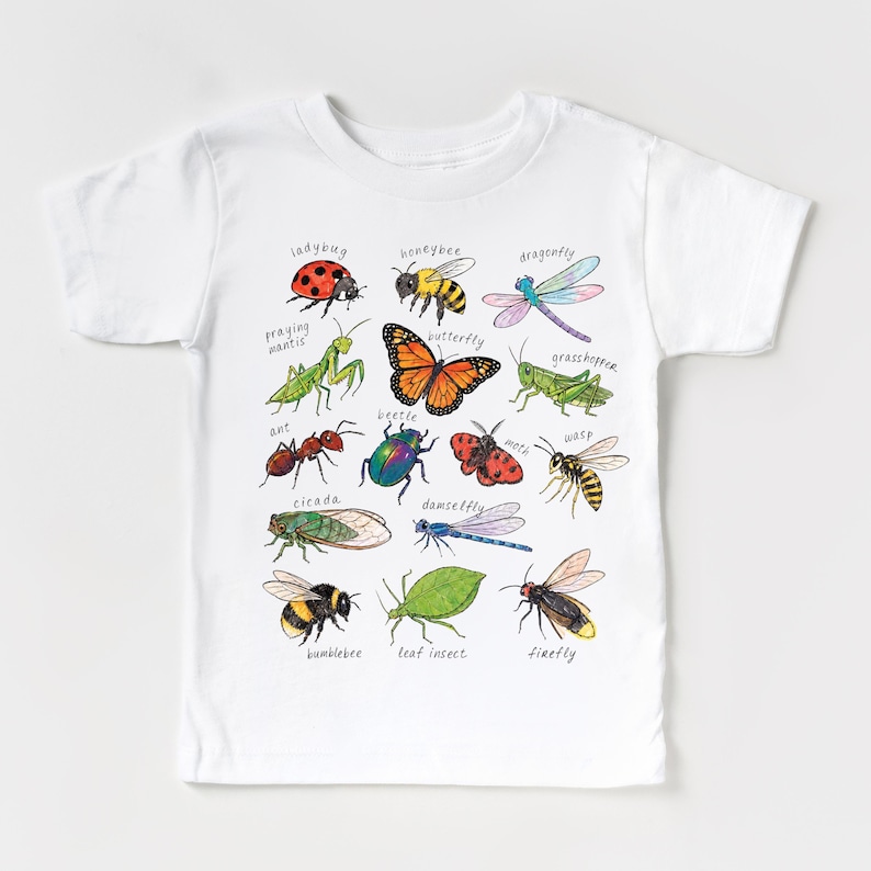 May include: White t-shirt with a colourful illustration of insects such as a ladybug, butterfly, and dragonfly. Each insect is labelled with its name in a handwritten font. The shirt is made of a soft, comfortable material.