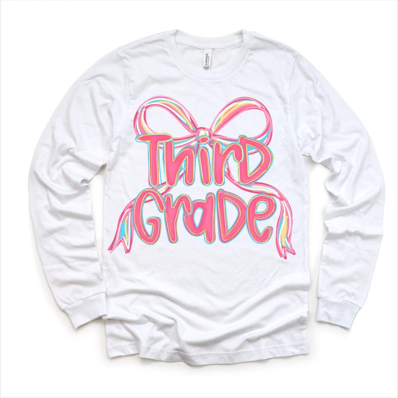 May include: White long-sleeve shirt with a colorful bow and the words "Third Grade" in pink. The bow has pastel rainbow accents. The shirt is made of a soft, comfortable material.
