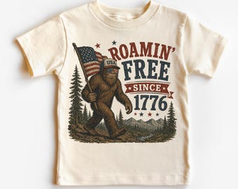 Roamin’ Free Since 1776 Kids T-Shirt – Patriotic Bigfoot USA Graphic Tee -4th Of July Shirt