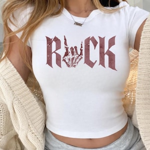 A white t-shirt with the word "ROCK" printed in a distressed font.
