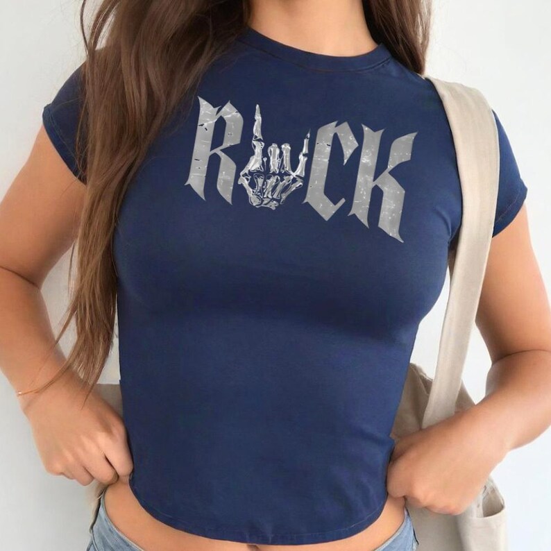A woman wearing a navy blue t-shirt with the word "Rock" printed on it.