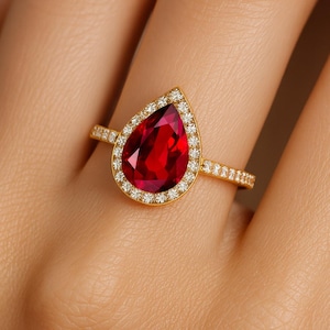 Anillo de compromiso con halo de diamantes y rubí en forma de pera: oro de 14 k, ideal para bodas y compromisos.